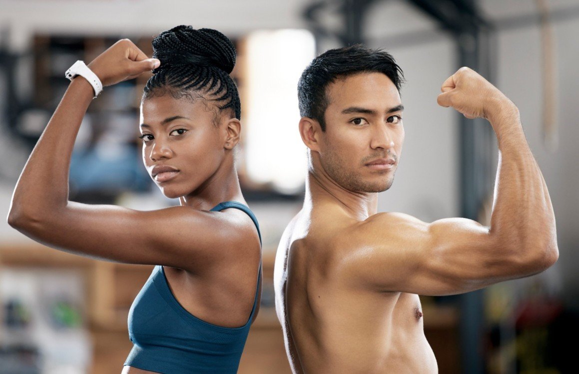 Black woman and man flexing muscles in a fitness setting, representing strength and muscle tone, relevant to Emsculpt Neo body contouring treatments.