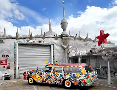 Colorful art car parked outside the Art Car Museum, featuring a vibrant design and whimsical decorations, showcasing Houston's unique artistic culture.