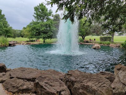 Fountain in a tranquil park setting with lush greenery and rocky surroundings, highlighting outdoor wellness and relaxation in Sugar Land.